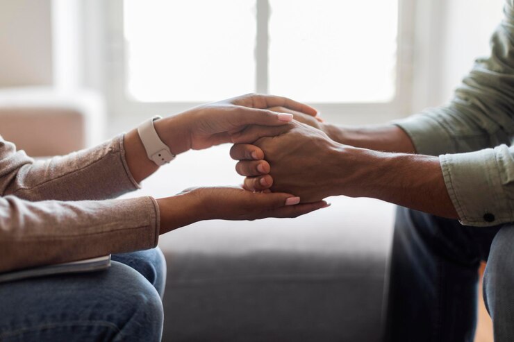 Photo thérapeute de femme noire méconnaissable tenant les mains d'un patient