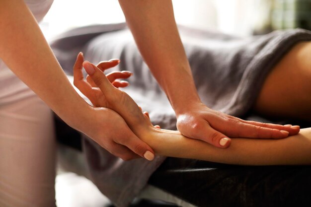 Photo thérapeute massant les mains au spa