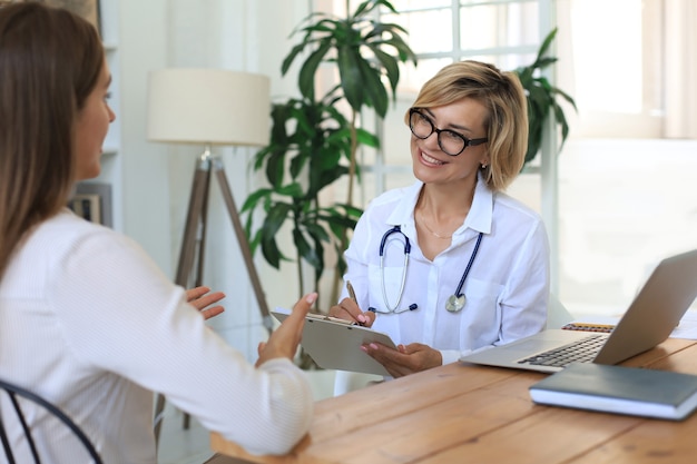 Thérapeute médecin d'âge moyen en consultation avec le patient au bureau.