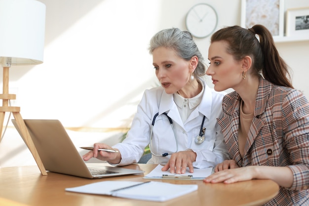 Thérapeute médecin d'âge moyen en consultation avec le patient au bureau.