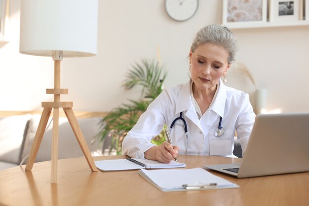 Thérapeute médecin femme d'âge moyen en consultation.