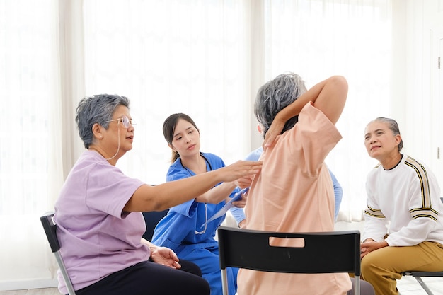 Le thérapeute soignant est assis avec un groupe de personnes âgées asiatiques dans un cercle pour vérifier la santé physique et mentale lors d'une séance de thérapie de groupe pour personnes âgées La maison de retraite facilite un groupe de soutien