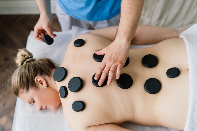 Thérapie de massage aux pierres chaudes pour grosse femme, maître masculin