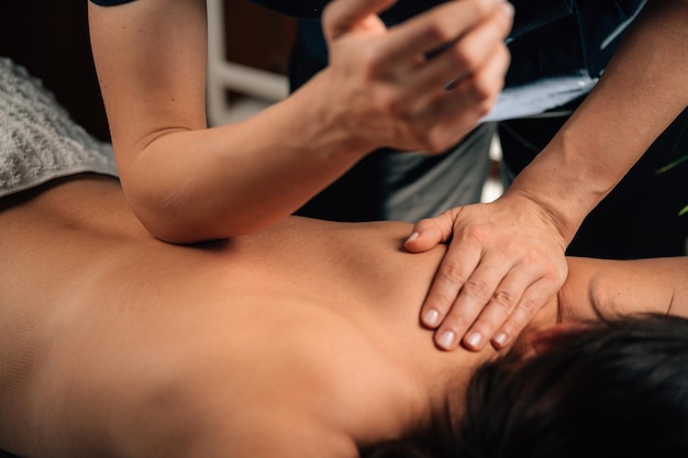 Thérapie de massage des tissus profonds. Thérapeute massant le dos de la femme, en utilisant la pression du coude.