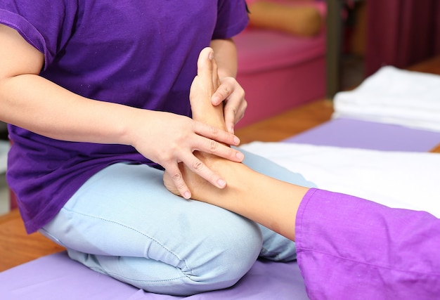 Photo thérapie de médecine alternative de massage de pied thaï avec l'huile d'arome d'herbe thaïe