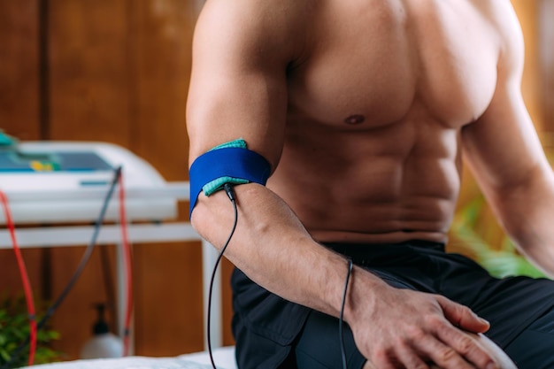 Thérapie physique du coude avec électrodes TENS Stimulation nerveuse électrique transcutanée