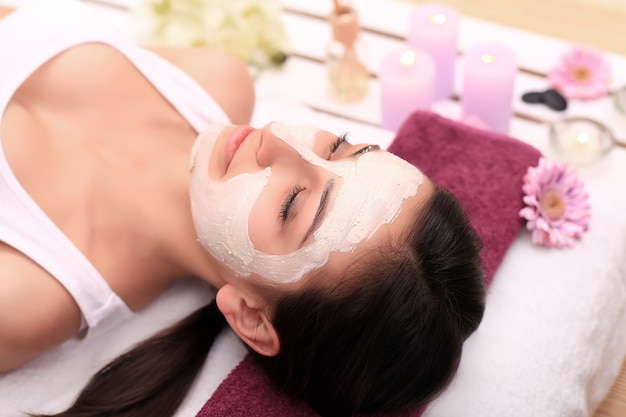 Thérapie thermale pour jeune femme ayant un masque facial au salon de beauté