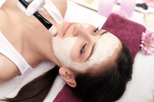 Thérapie thermale pour jeune femme ayant un masque facial au salon de beauté