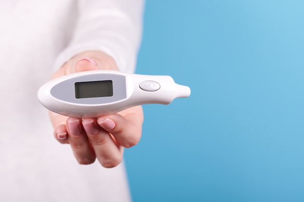Thermomètre électronique dans une main de femme