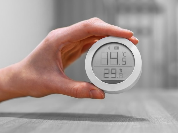 Thermomètre d'intérieur avec des chiffres de température et d'humidité faibles Concept de maison froide mauvaises conditions insalubres