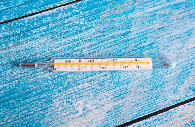 Photo thermomètre à mercure avec mouchoir sur fond bleu concept de maladie