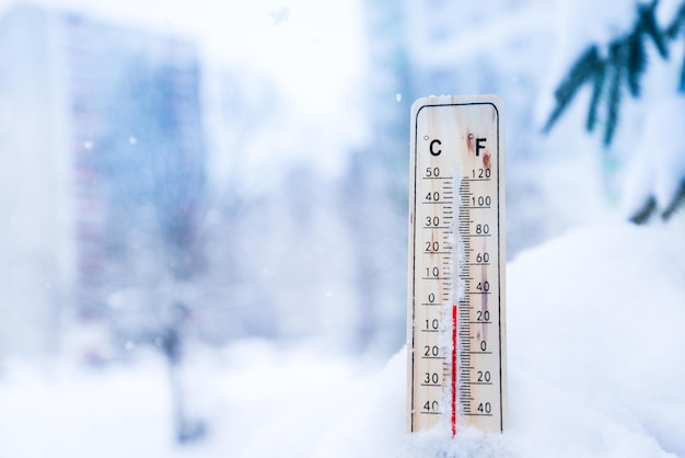 Thermomètre sur neige avec des températures basses en degrés Celsius ou Fahrenheit en hiver.