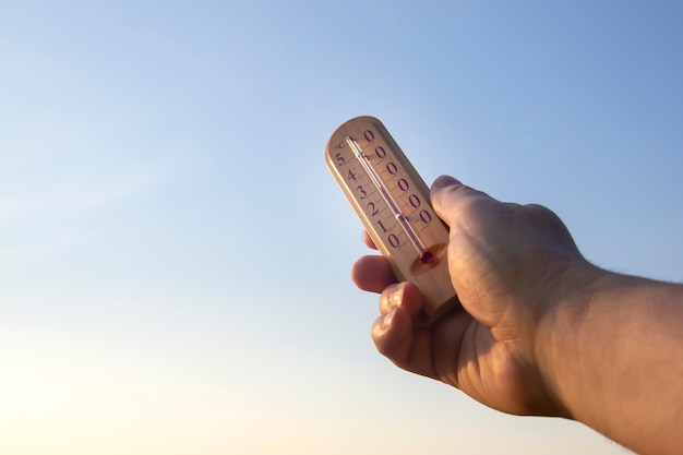 Thermomètre pour mesurer la température dans la nature sur fond de ciel par temps chaud d'été