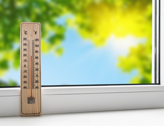 Thermomètre sur le rebord de la fenêtre sur le fond de la chaleur estivale