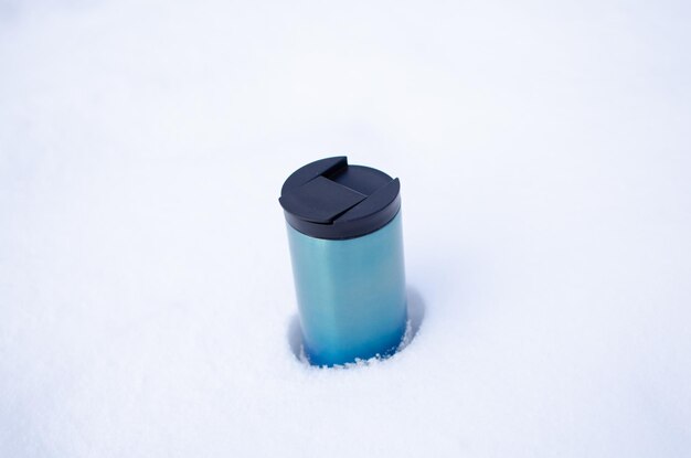 Thermos avec café dans la neige