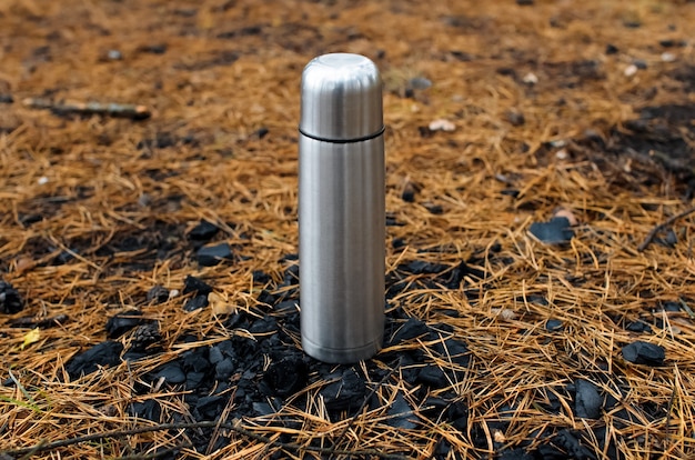 Thermos dans la forêt se dresse sur des charbons