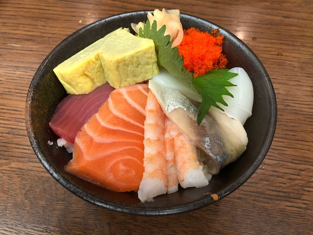 Thon frais et saumon glissent avec bol de riz sur la table