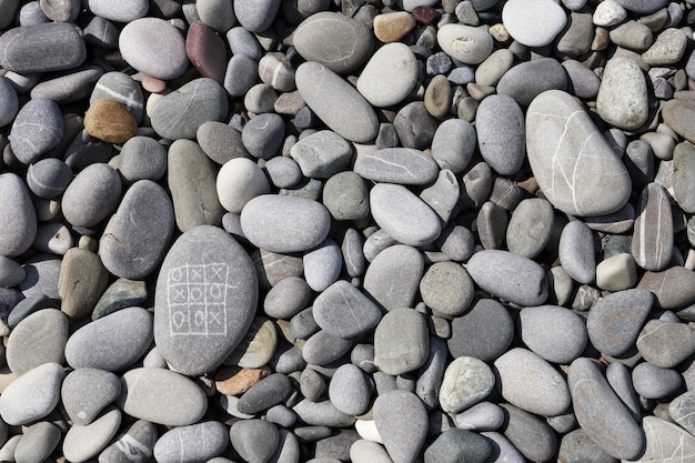 Tic-tac-toe sur les galets du bord de mer