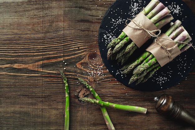 Une tige crue comestible d'asperge sur un fond en bois