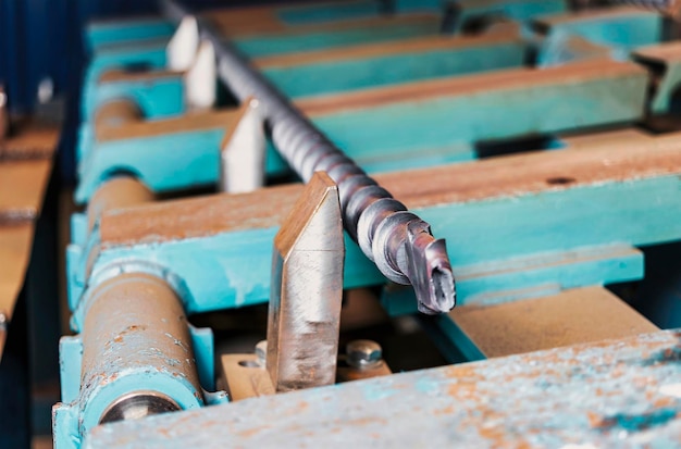 Une tige métallique chauffée dans un four à induction après traitement Le métal chaud se refroidit Travail des métaux dans l'atelier industriel de l'usine