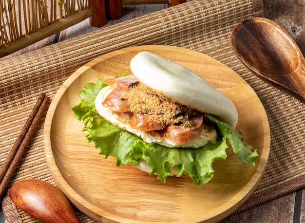 Tigre mord un sandwich à l'argent servi dans un plat en bois isolé sur la vue latérale de la table de la nourriture taïwanaise
