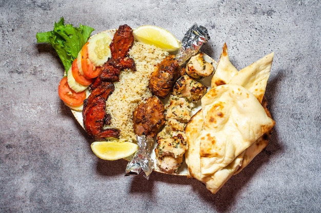 Tikka boti seekh kabab plateau avec pulao roti citron vert et salade dans un plat vue de dessus du plat de barbecue du moyen-orient