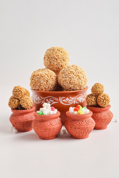 Photo til gul ou boule de graines de sésame sucré ou laddu avec fikri pour le festival indien makar sankranti sur fond blanc.