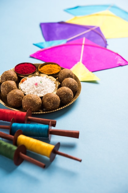 Til Gul OU Sweet Sesame Laddu avec modèle miniature Fikri et Kite avec haldi Kumkum et cristaux de sucre pour le festival Makar Sankranti sur fond de mauvaise humeur, mise au point sélective