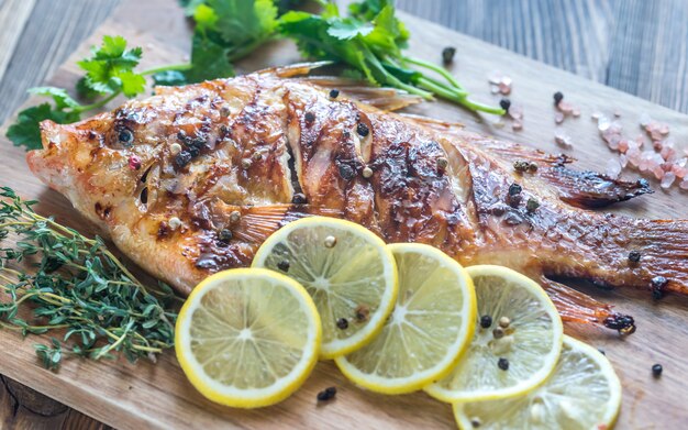 Tilapia grillé aux herbes sur la planche de bois