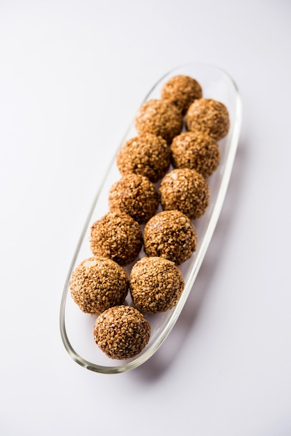 Tilgul Laddu ou boules Til Gul pour makar sankranti, c'est un aliment sain à base de sésame, de cacahuètes concassées et de jaggery. servi dans un bol. mise au point sélective montrant les détails.