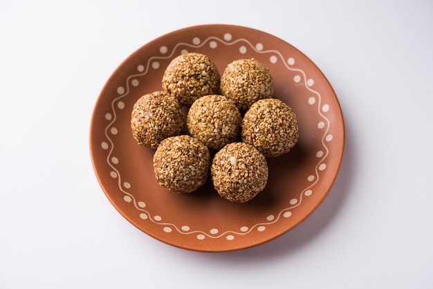 Tilgul Laddu ou boules Til Gul pour makar sankranti, c'est un aliment sain à base de sésame, de cacahuètes concassées et de jaggery. servi dans un bol. mise au point sélective montrant les détails.