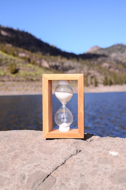 Photo time concept sablier de sable blanc sur les roches volcaniques