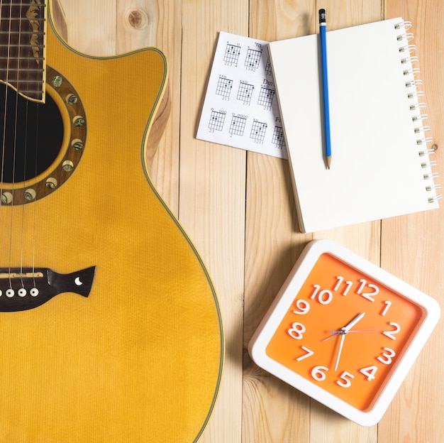 Time for Guitar écrit une chanson avec une horloge rouge.