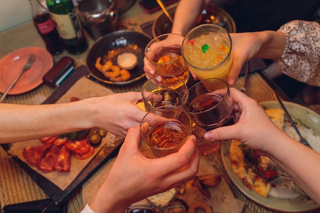 Tintement des verres avec de l'alcool et des toasts, fête.