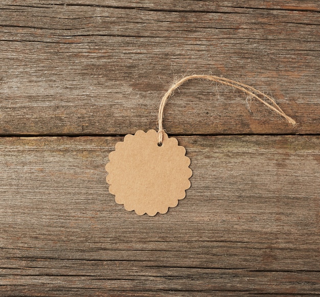 Étiquette ronde en papier brun vide attaché avec une chaîne blanche