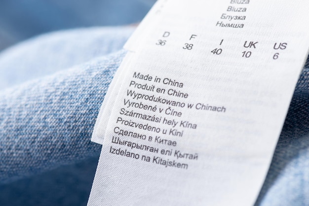 Étiquette de vêtements mentionnant la taille du nom et le pays où le produit a été fabriqué Produits textiles fabriqués en Chine gros plan sur la description des vêtements