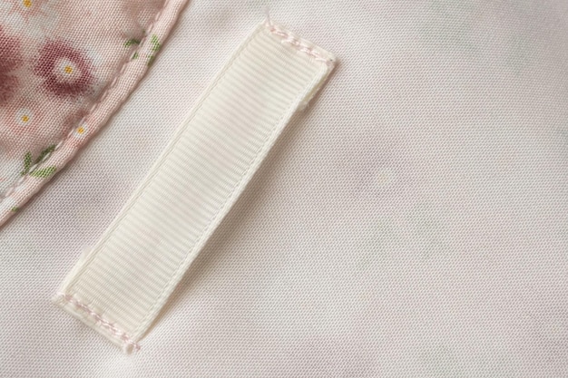 Étiquette de vêtements de soin de lessive vierge sur fond de texture de tissu
