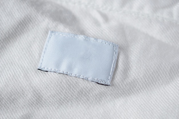 Étiquette de vêtements de soins de blanchisserie vierge blanche sur chemise en coton