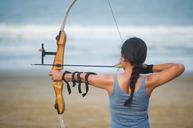 Tir à l'arc asiatique avec tir à l'arc sur la plage