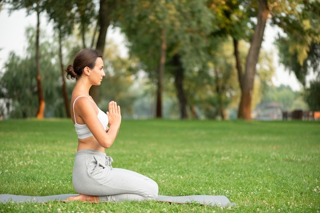 Tir complet femme pratiquant le yoga sur tapis