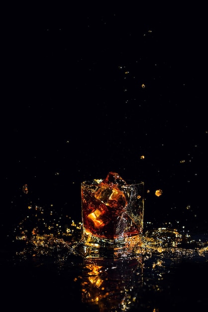 Tir isolé de whisky avec splash sur fond noir