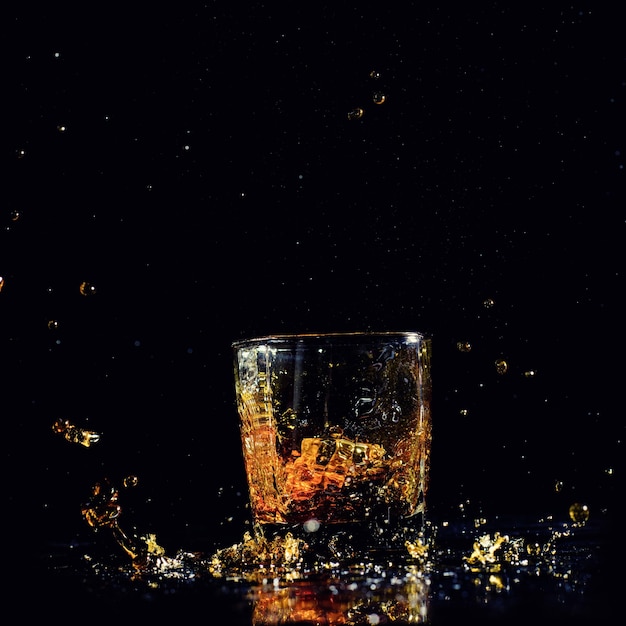 Tir isolé de whisky avec splash sur fond noir