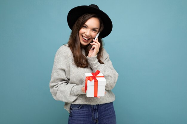 Tir de jolie jeune femme brune drôle positive heureux isolé sur fond bleu mur