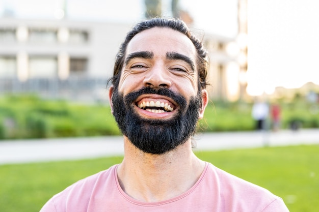 Tir à la tête d'un homme barbu hispanique souriant à la caméra