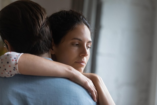 Tir à la tête jeune femme malheureuse et réfléchie étreignant son mari se sentant stressé après un conflit pensant à des problèmes psychologiques dans les relations familiales bouleversée épouse soupçonnant la trahison ou la tricherie