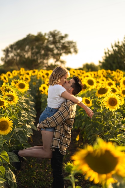 Tir vertical d'un beau couple caucasien au champ de tournesols en Espagne