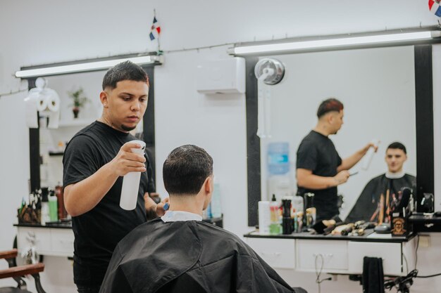 Photo tir vertical d'un coiffeur pulvérisant de l'eau tout en peignant son client