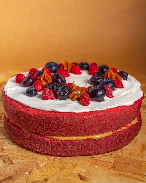 Tir Vertical D'un Délicieux Gâteau De Velours Rouge Décoré De Baies Sur Une Surface En Bois