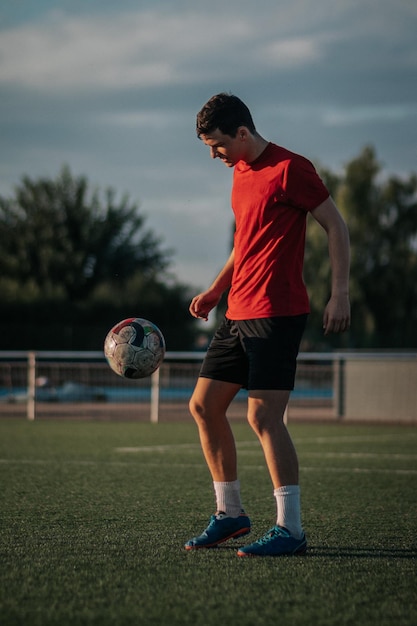 Tir vertical d'un joueur faisant des touches avec ses pieds sur le terrain de football.