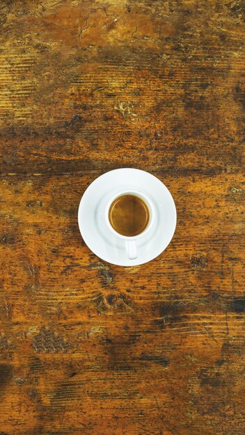 Tir vertical d'une tasse de café sur une table en bois